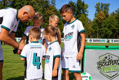 Trainer bespricht sich mit einer Gruppe Kinder