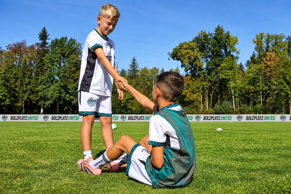 Zwei Kinder im Bolzplatz United Trikot geben sich nach dem Spiel die Hand