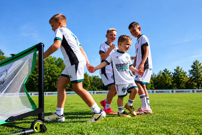 Kinder laufen Hand in Hand über den Platz